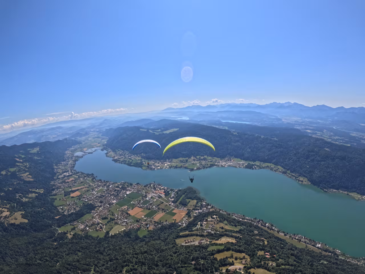 Zwei Tandem-Gleitschirme im Flug über dem Ossiacher See