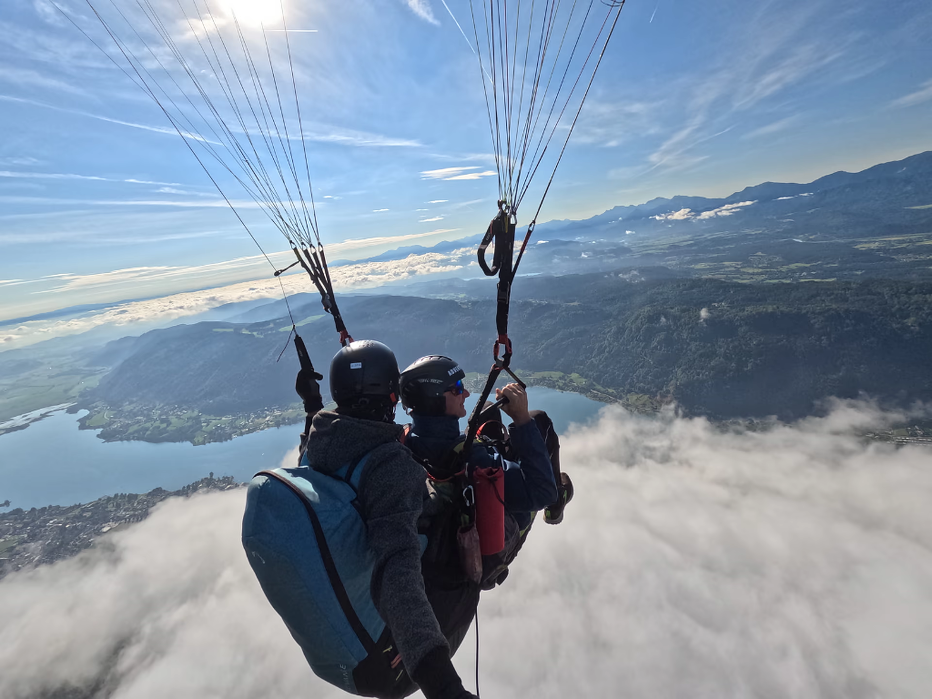 Tandemflug über dem Wolkenmeer mit Blick auf den Ossiacher See
